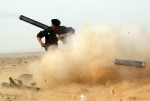 A rebel fighter fires a cannon during a battle near Ras Lanuf